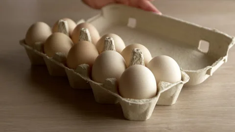 Raw chicken eggs in a tray are opened by hand. Stock Footage 314269360