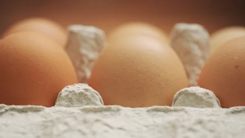 Raw chicken eggs in a tray on a brown background, slider shot 4K UHD Stock-Footage 151645109