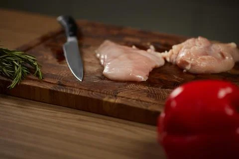 Raw chicken fillets on cutting board with knife Stock Photos