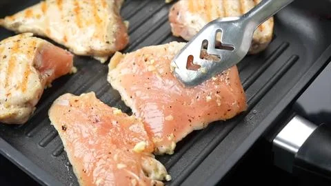 Raw Chicken fried in grill pan Stock Photos