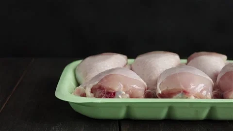 Raw chicken legs package on black background slider camera Stock Footage 154347752