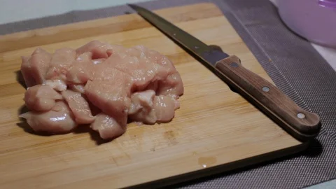 Raw chicken meat on a cutting board, cooking at home Stock Footage 128387825