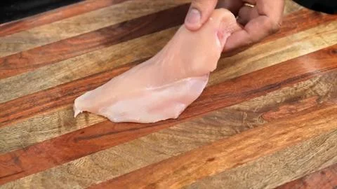 Raw chicken meat slices on board in kitchen room Stock Photos