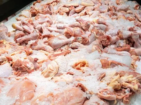 Raw chicken pieces displayed on a bed of crushed ice at a supermarket meat .. Stock Photos