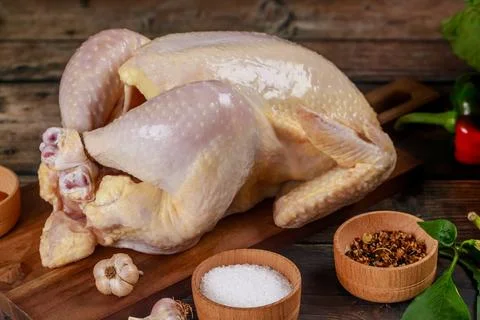 Raw chicken is placed on cutting board ready for cooking. Stock Photos