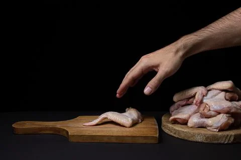 Raw chicken wings on a black background. Fresh chicken meat.  Stock Photos