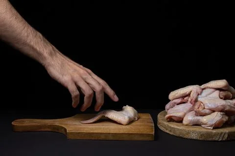 Raw chicken wings on a black background. Fresh chicken meat.  Stock Photos