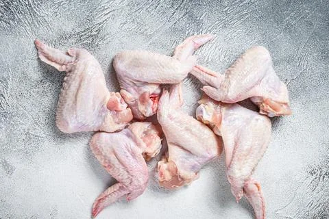 Raw chicken wings on a kitchen table. White background. Top view Stock Photos
