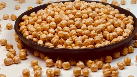 Raw chickpeas in dark plate, white background, horizontal format, angled view Stock Footage 336471549
