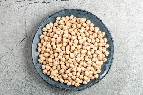 Raw chickpeas in the plate on the table. Stock Photos