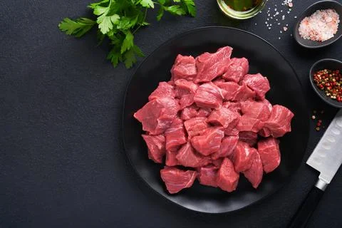 Raw chopped beef meat. Raw organic meat beef or lamb, spices, herbs on black  Stock Photos