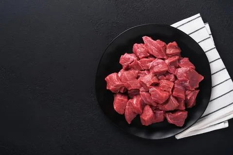 Raw chopped beef meat. Raw organic meat beef or lamb, spices, herbs on black  Stock Photos