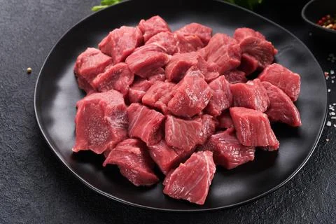 Raw chopped beef meat. Raw organic meat beef or lamb, spices, herbs on black  Stock Photos