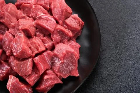 Raw chopped beef meat. Raw organic meat beef or lamb, spices, herbs on black  Stock Photos