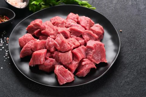 Raw chopped beef meat. Raw organic meat beef or lamb, spices, herbs on black  Stock Photos