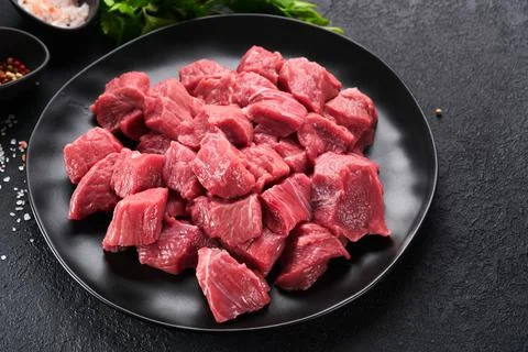 Raw chopped beef meat. Raw organic meat beef or lamb, spices, herbs on black  Stock Photos
