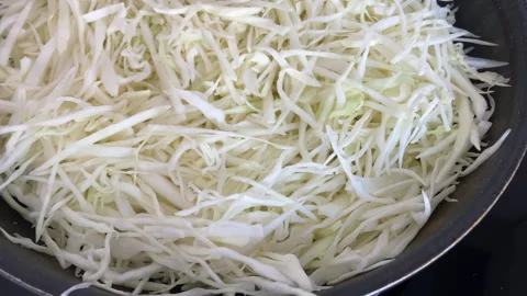 Raw chopped cabbage in a frying pan ready to cooking. Close-up. Stock Footage 302246061