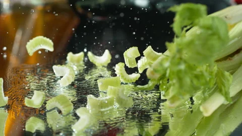 Raw Chopped Celery Falling Splashing Water Drops around the Kitchen Stock Footage 131742242