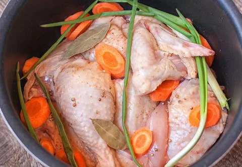 Raw chopped chicken in multicookings Stock Photos