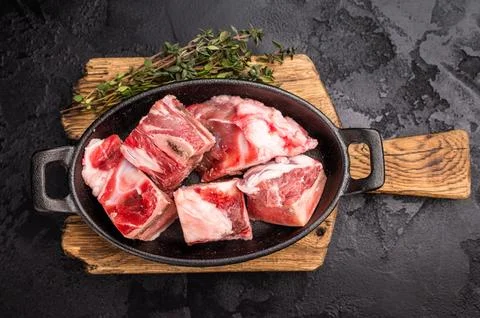 Raw chopped  lamb meat with bones, uncooked mutton ready for cooking. black.. Stock Photos