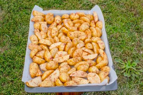 Raw chopped potatoes on a baking sheet. Stock Photos