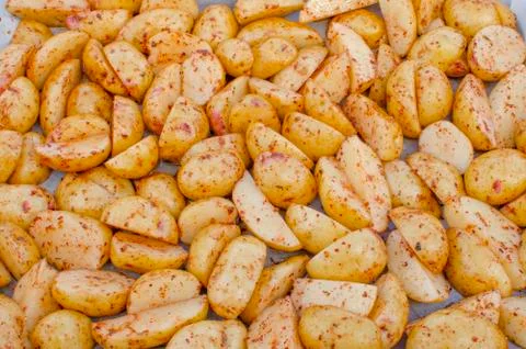 Raw chopped potatoes on a baking sheet. Stock Photos