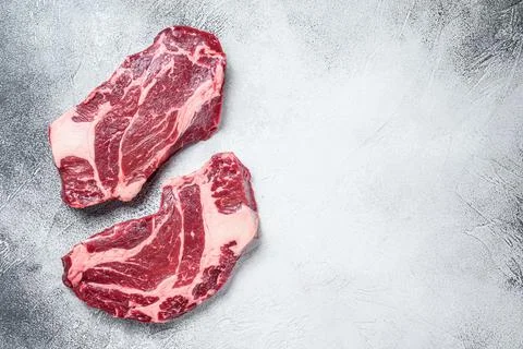 Raw chuck eye roll steaks premium beef meat. White background. Top view. Copy Stock Photos