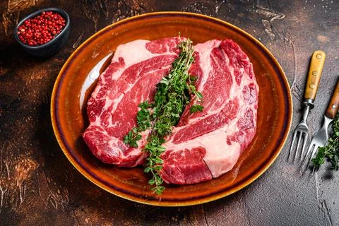 Raw Chuck eye roll steaks organic beef meat. Dark background. Top view Stock Photos
