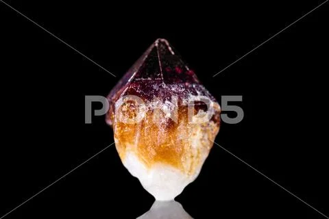 Raw citrine quartz mineral stone in front of black background Stock Photos