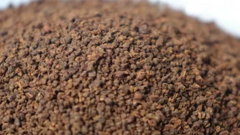 Raw coarse dried tea leaf powder drops in a bowl video. Closeup. Stock Footage 278343756