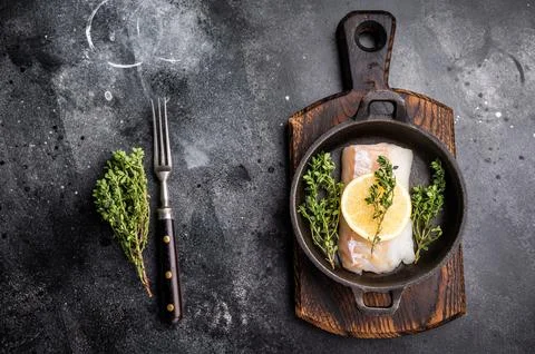Raw cod fish fillets, whitefish without skin in skillet. black background. .. Stock Photos