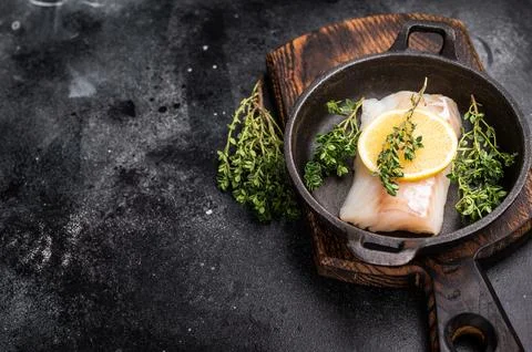 Raw cod fish fillets, whitefish without skin in skillet. black background. .. Stock Photos