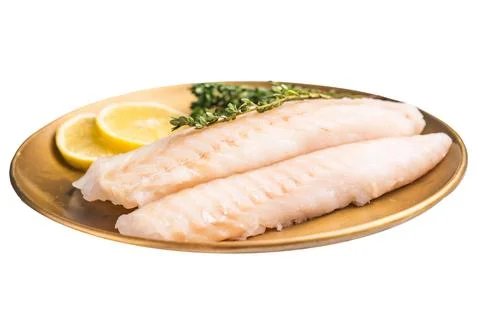 Raw cod loin pieces, whitefish fillets without skin on plate with herbs iso.. Stock Photos