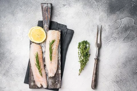Raw cod Loin, white fish fillets without skin on wooden board. white backgr.. Stock Photos