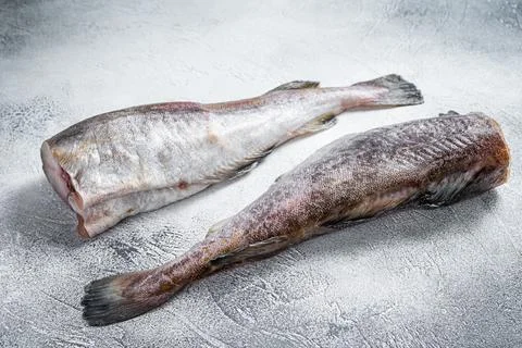 Raw cod whole fish on kitchen table. White background. Top view Stock Photos