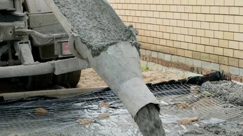 Raw concrete solution is poured through a tube of cement truck onto the Stock Footage 285637066