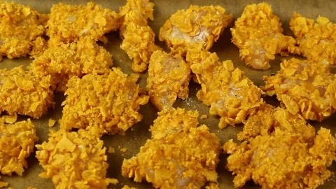 Raw corn flake crumbs chicken nuggets on baking sheet Stock Footage 77222030