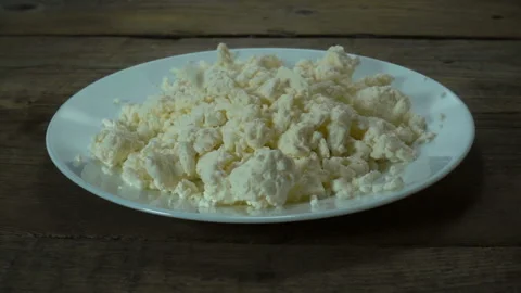 Raw cottage cheese drops in slow motion in a plate Stock Footage 132348449
