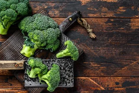 Raw Cut broccoli on a cutting board. Dark wooden background. Top view. Copy Stock Photos
