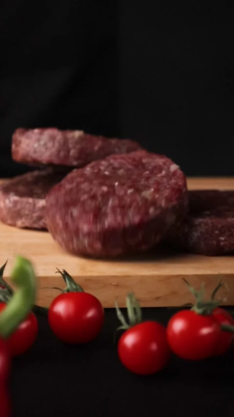 Raw cutlets fall on a wooden board farm products Stock Footage 262875185