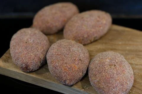 Raw cutlets made of ground beef meat on a wooden chopping board. Stock-Fotos