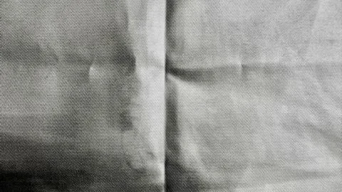 Raw denim fabric macro texture revealing dramatic seams and soft folds in moo Stock Photos