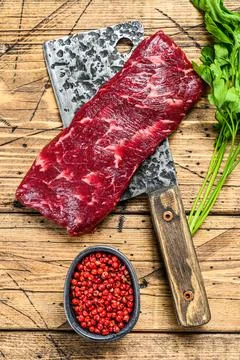 Raw denver beef meat steak on a cleaver. wooden background. Top view Stock Photos