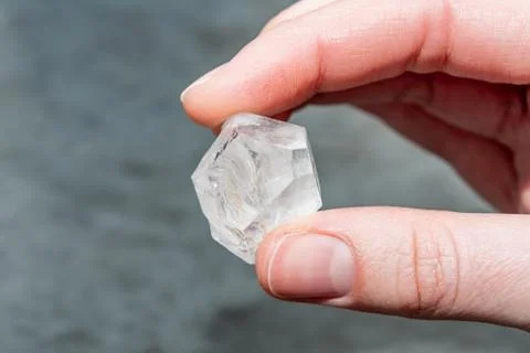 Raw diamond big dob between two fingers thumb and forefinger Stock Photos