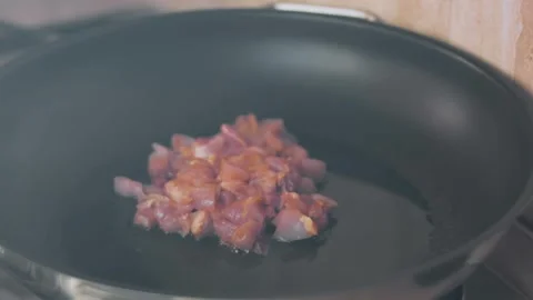 Raw diced chicken placed into an empty frying pan, 4K Stock Footage 341121792