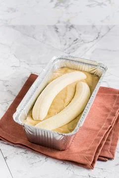 Raw dough for banana bread in a baking dish on the table. Social media tren.. 스톡 사진