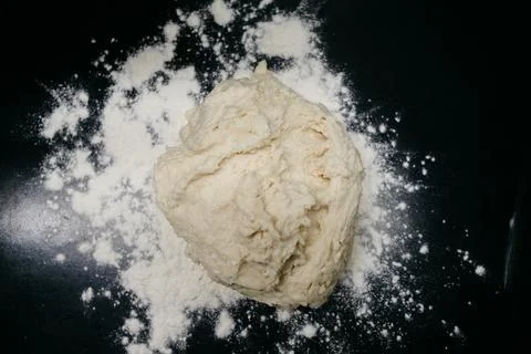 Raw dough on a black table with side light Stock Photos