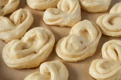 Raw dough for buns on baking paper, close-up. Stock Photos