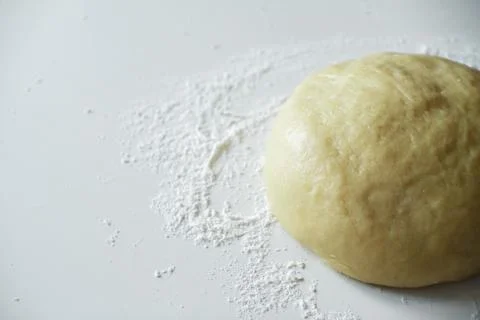 Raw dough lying on the table on a white background. A piece of dough for brea Stock Photos