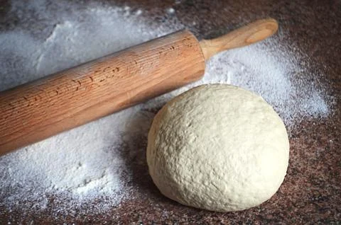 Raw dough with rolling pin Stock Photos
